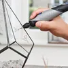 A hand is using a Dremel rotary tool to engrave a glass terrarium. Anteprima dell’immagine prodotto