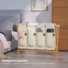 A laundry basket with four compartments is placed next to a bed in a bedroom. Anteprima dell’immagine prodotto