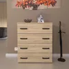 A modern wooden chest of drawers with black handles stands against a neutral wall, with an umbrella stand to the right. Podgląd zdjęcia produktu