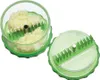 Two parts of a clear plastic garlic chopper with green accents and silver blades are shown against a white background. One part contains chopped garlic. Produktbild-Vorschau