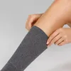 A person is putting on a gray sock. Produktbild-Vorschau