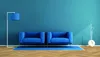 Two blue armchairs in a room with a blue wall and a wooden floor. Produktbild-Vorschau