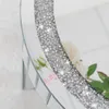 A close-up view of a round, mirrored side table with a decorative band of crystals. Anteprima dell’immagine prodotto