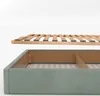 A close-up view of a bed frame with a slatted base hovering above it, against a white background. Produktbild-Vorschau