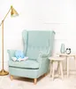 A plush octopus toy sits on a mint green armchair next to two small side tables, one with a vase and alarm clock. A gold floor lamp is to the left. Náhľad obrázku produktu