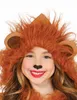 A young girl wearing a lion costume hood with ears and a mane, smiling and looking at the camera. Produktbild-Vorschau