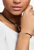 A close-up shot of a woman wearing a white top and jewelry. Produktbild-Vorschau