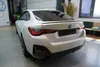 The rear of a white BMW car is shown in a garage or showroom. Anteprima dell’immagine prodotto