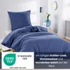 A blue duvet and pillow on a bed, with decorative elements in the background. Produktbild-Vorschau