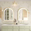 A modern bathroom vanity with two arched LED mirrors, sinks, and green cabinets, decorated with floral wallpaper. Náhled obrázku produktu