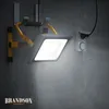 A bright LED work light is mounted on a concrete wall, plugged into a wall socket. Anteprima dell’immagine prodotto