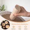 A hand is holding a wooden cylinder over a beige cat sofa with a fluffy white trim. Produktbild-Vorschau