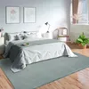 A bedroom scene with a bed, rug, and furniture. Produktbild-Vorschau