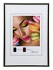 A framed picture of a woman with colorful makeup and macarons. Produktbild-Vorschau