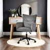 A gray corduroy office chair is placed in front of a wooden vanity table with a round mirror above it. The scene is set against a dark gray wall with white curtains on the side. Náhľad obrázku produktu