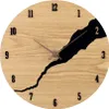 A round wooden clock with black numbers and a black abstract design. Anteprima dell’immagine prodotto