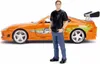 A miniature orange Toyota Supra with a figurine of a man standing next to it. Anteprima dell’immagine prodotto