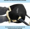 Hands wearing grey knitted gloves are inserted into a black lambskin hand warmer attached to a stroller handle. Produktbild-Vorschau