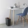 A modern desk setup with a trash can, desk, chair, and lamp. Produktbild-Vorschau