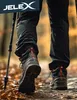 A person is hiking on a path covered with fallen leaves, using trekking poles. Produktbild-Vorschau