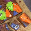 A close-up overhead view of several Halloween-themed brownies decorated with colorful frosting and candy eyes. Náhled obrázku produktu