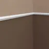 A corner of a room showing white molding on two brown walls. Anteprima dell’immagine prodotto