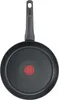 A black frying pan with a red heat indicator in the center and a gray handle, shown from the underside. Podgląd zdjęcia produktu