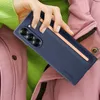 A hand holding a dark blue phone case with a rose gold accent, over a pink jacket and green sweater. Produktbild-Vorschau