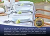 A table setting with white cloth napkins and plates, decorated with small white flowers. Produktbild-Vorschau