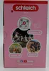 The image shows the back of a pink Schleich product box with various circular images of horses and people, along with text and social media icons. Produktbild-Vorschau
