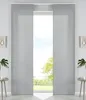 A pair of gray panel curtains are shown in a room, framing a view of trees and sky outside a window. Produktbild-Vorschau