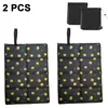 Two foldable outdoor seat cushions with a lemon pattern are displayed, along with two black storage bags. Produktbild-Vorschau
