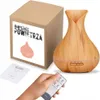 A product shot of an aroma diffuser, its packaging, a manual, and a remote control, with a hand holding the remote. Produktbild-Vorschau
