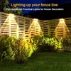 Solar lights illuminating a wooden fence and garden at night. Produktbild-Vorschau