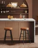 A bar area with two stools in the foreground and shelves with bottles and decor in the background. Produktbild-Vorschau