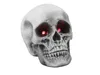 A close-up of a Halloween skull decoration with glowing red eyes. Anteprima dell’immagine prodotto