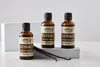 Three bottles of vanilla extract are displayed on a white surface, with two vanilla beans in the foreground. Náhled obrázku produktu
