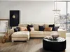 A living room scene with a sectional sofa, ottoman, and decorative items, with a city view through a large window. Náhled obrázku produktu