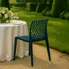 A dark blue chair sits next to a table set for a meal in a garden. Produktbild-Vorschau