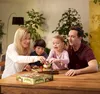 A family playing a board game at a wooden table. Produktbild-Vorschau