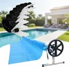 A pool cover roller and cover are shown in a backyard setting with a swimming pool and house. Náhľad obrázku produktu