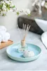 A spa-like bathroom setting with a reed diffuser, a decorative shell, and rolled towels. Náhľad obrázku produktu