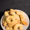 A close-up shot of a plate of cookies on a dark background. Produktbild-Vorschau