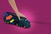 A child's hand is shown resting on a toy Batmobile transporter. Anteprima dell’immagine prodotto
