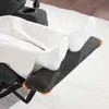 A person's legs and feet are resting on the footrest of a recliner chair. Produktbild-Vorschau