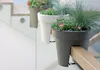 Three planters with plants are attached to a wooden railing on a staircase. Náhled obrázku produktu