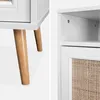 Collage of close-up shots of a white bedside table with wooden legs and a rattan drawer front. Produktbild-Vorschau