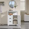 A white wooden bathroom cabinet with three drawers and an open door revealing shelves with toiletries and towels. A round mirror hangs on the wall above the cabinet. Produktbild-Vorschau