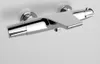 A close-up studio shot of a chrome shower thermostat mounted on a white wall. Produktbild-Vorschau