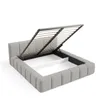 A grey upholstered bed frame with the mattress support mechanism lifted to reveal the storage space underneath. Produktbild-Vorschau